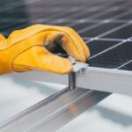 Stocker l'énergie de vos panneaux solaires, la vérité sans filtre Batterie de stockage solaire installée dans un garage résidentiel avec panneaux photovoltaïques visibles