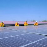 Installateur posant des panneaux solaires photovoltaïques sur toiture maison individuelle