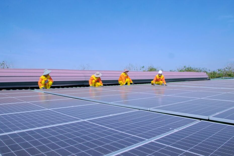 Installateur posant des panneaux solaires photovoltaïques sur toiture maison individuelle