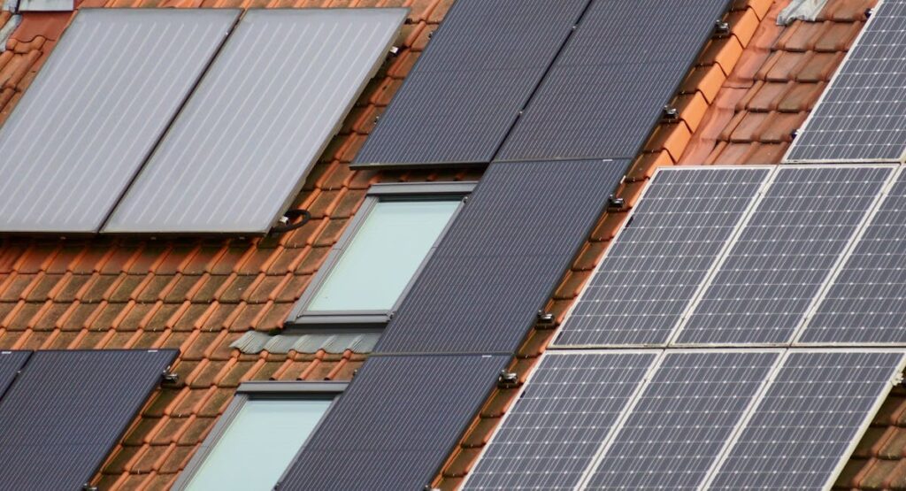 Technicien installant des panneaux solaires photovoltaïques sur toiture résidentielle ensoleillée