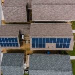 Panneaux solaires sur toit de maison individuelle avec batterie de stockage lithium en garage
