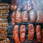 Bouteille de propane orange sur terrasse extérieure avec barbecue gaz allumé