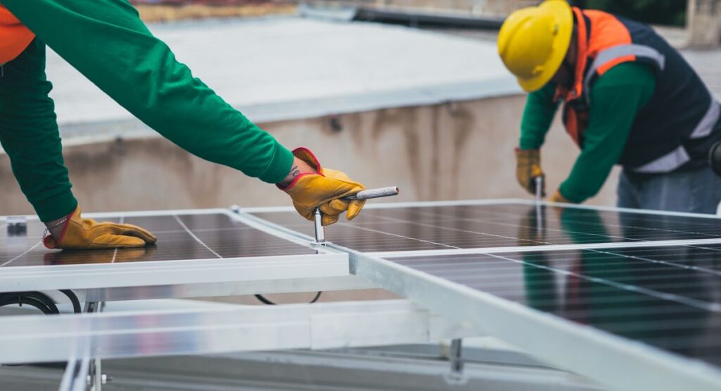 Technicien posant des panneaux solaires photovoltaïques sur toiture résidentielle ensoleillée