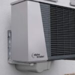 Le contrat chaleur renouvelable ADEME décrypté sans langue de bois Technicien installant une pompe à chaleur sur un bâtiment industriel urbain