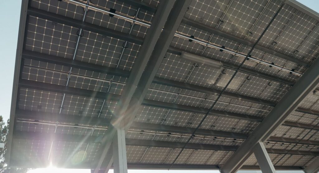 Installateur posant des capteurs solaires thermiques sur toiture inclinée maison