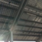 Installateur posant des capteurs solaires thermiques sur toiture inclinée maison