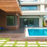 Panneaux photovoltaïques installés sur toit orienté sud pour alimenter pompe à chaleur de piscine extérieure