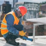 Technicien installant des panneaux solaires sur toiture maison individuelle