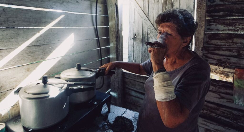 Intérieur sombre avec poêle à bois défaillant, vitre noircie par les fumées