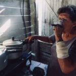 Intérieur sombre avec poêle à bois défaillant, vitre noircie par les fumées