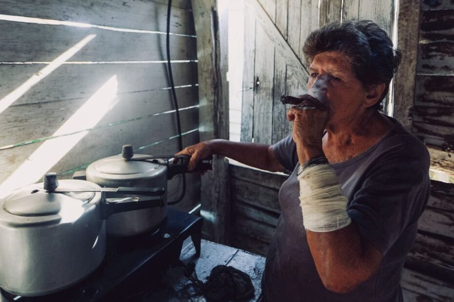 Intérieur sombre avec poêle à bois défaillant, vitre noircie par les fumées